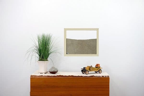cream painted wood frame ant farm hanging on wall