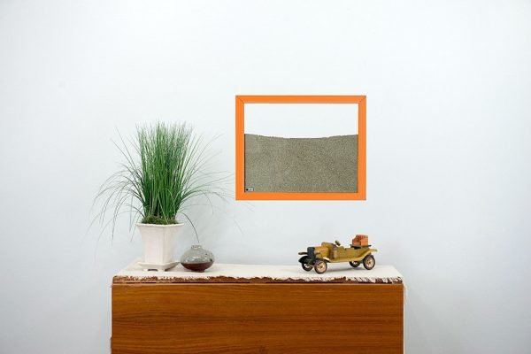 orange painted wood frame ant farm hanging on wall