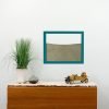 teal wood frame ant farm hanging on wall